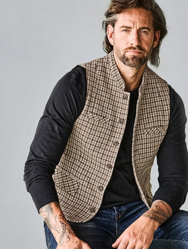 Mann in brauner Weste und schwarzem Sweatshirt