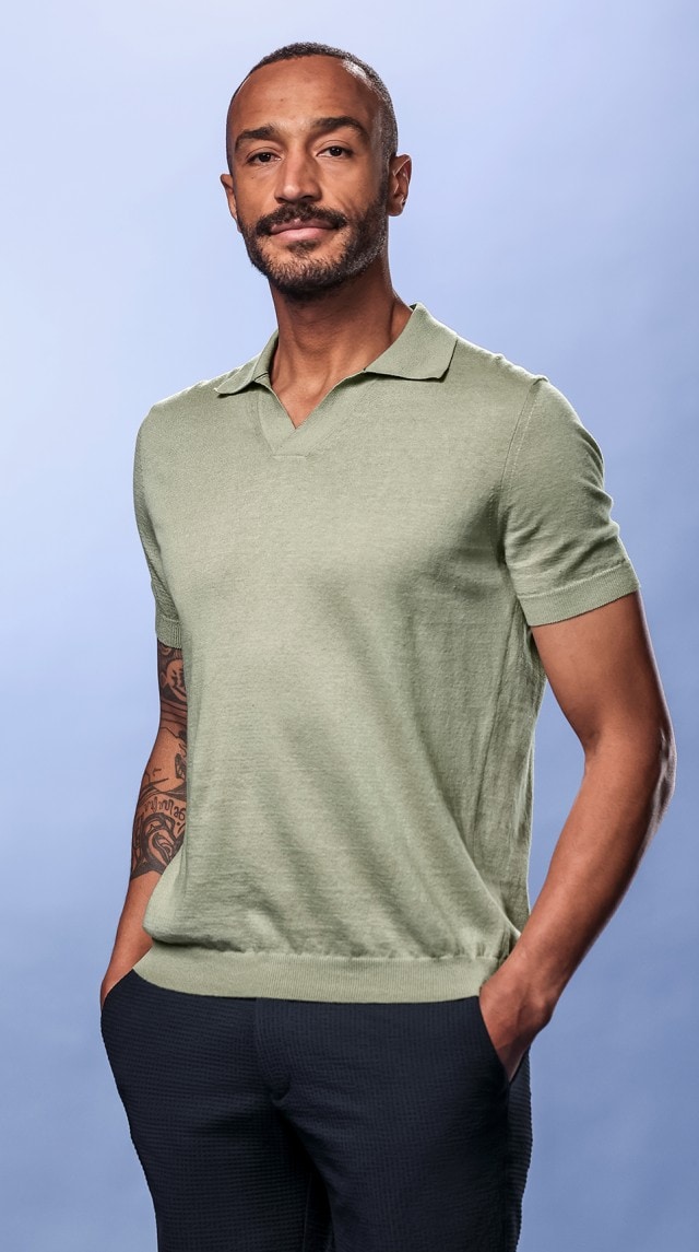 Ein Mann trägt ein beiges Poloshirt und schaut in die Kamera.