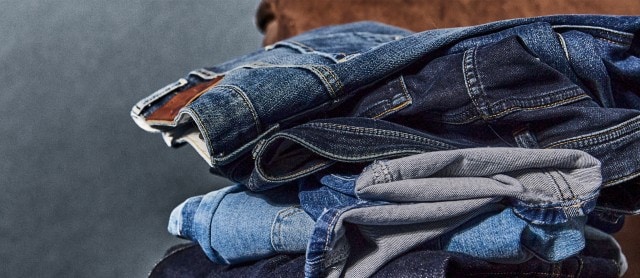 Gestapelte Jeanshosen in verschiedenen Farben