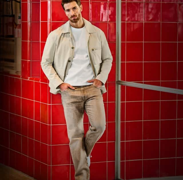 Ein zweigeteiltes Bild zeigt eine stehende Person in lässiger Kleidung, links in Nahaufnahme vor dunklem Hintergrund mit grünem Poloshirt und rechts in voller Länge vor einer roten gefliesten Wand mit heller Jacke und Jeans.