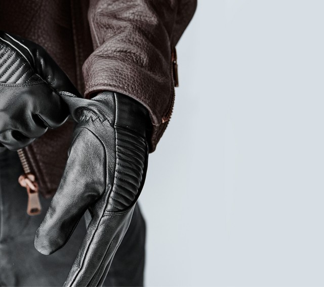 Nahaufnahme von den Händen eines Mannes der schwarze Lederhandschuhe trägt
