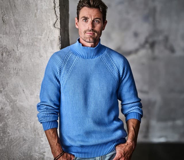 Auf dem Bild sieht man links einen Mann, der einen hellblauen Strickpullover trägt, und rechts eine Nahaufnahme der detaillierten Strickstruktur dieses Pullovers.