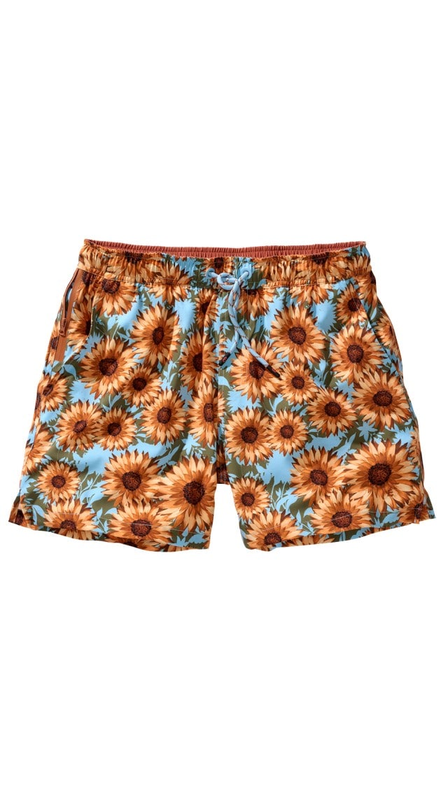 Die Abbildung zeigt eine Shorts mit einem Sonnenblumenmuster auf blauem Hintergrund.