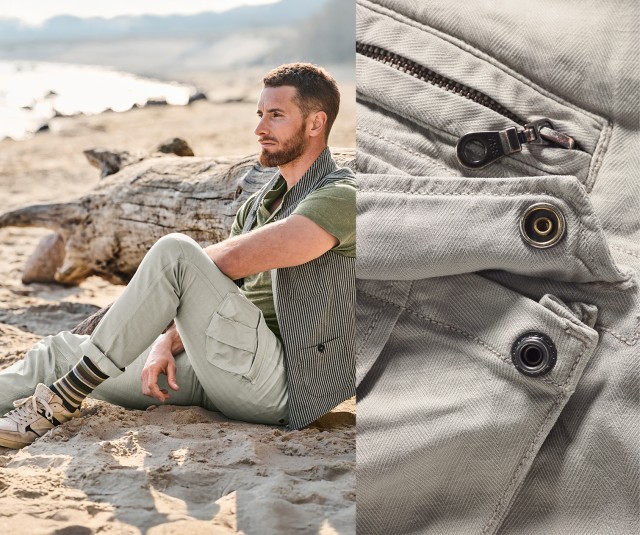 Auf dem Bild sitzt ein Mann am Strand, der ein grünes T-Shirt, eine gestreifte Weste, eine helle Cargohose und gemusterte Socken mit Sneakers trägt; daneben ist eine Detailaufnahme der Hose mit Reißverschluss und Druckknopf zu sehen.