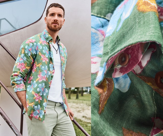 Auf dem Bild trägt ein Mann ein grünes, langärmliges Hemd mit buntem Blumenmuster über einem weißen T-Shirt sowie eine helle Stoffhose; rechts ist eine Detailaufnahme des floralen Hemdstoffs und eines Knopfes zu sehen.