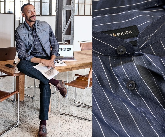 Auf dem Bild trägt ein Mann ein dunkelblaues Hemd mit weißen Nadelstreifen, eine graue Steppweste, eine karierte dunkelblaue Hose, bordeauxfarbene Socken und braune Lederschuhe.