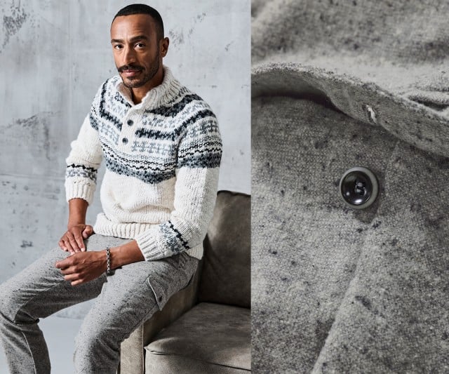 Ein Mann trägt einen dicken, cremefarbenen Strickpullover mit dunkelgrauem Norweger-Muster und Knopfleiste am Kragen sowie eine graue Wollhose mit Taschen.