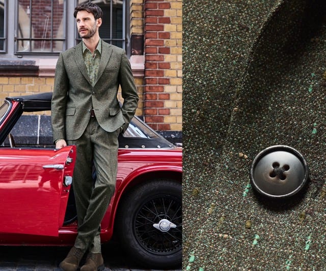 Ein Mann trägt einen olivgrünen Anzug aus strukturiertem Stoff mit passender Hose und Sakko, kombiniert mit einem gemusterten Hemd in Grüntönen und braunen Schuhen.