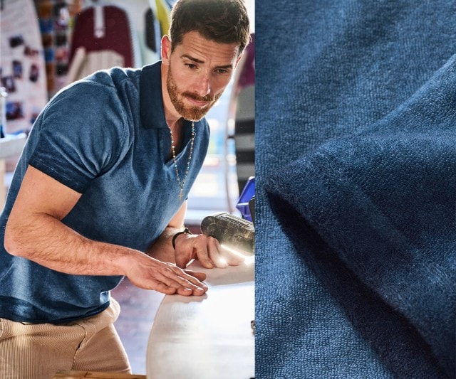 Mann trägt ein dunkelblaues Polo mit beigen Shorts und einer Talisman-Kette
