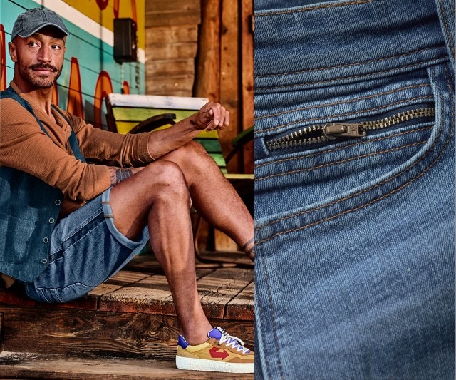Mann trägt dunkelblaue Shorts, dazu einen langärmeliges Shirt und eine Jeansweste