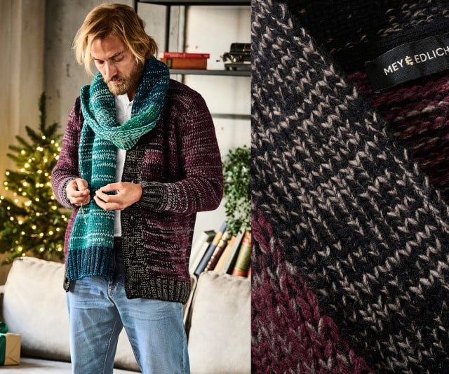 Das Bild zeigt einen Mann in gemütlicher Umgebung, der eine Strickjacke und einen grünen Schal trägt.