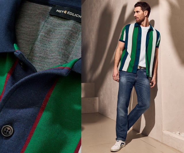 Ein Mann trägt ein grün-blau gestreiftes Hemd, ein weißes T-Shirt und Jeans.