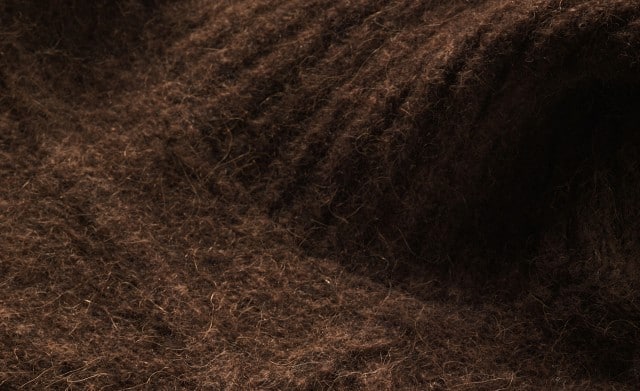 Das Bild zeigt eine Nahaufnahmefoto von einem Ärmel aus Alpakawolle.