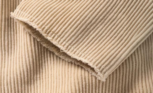 Das Bild zeigt eine Nahaufnahme von einem Ärmel aus Cord