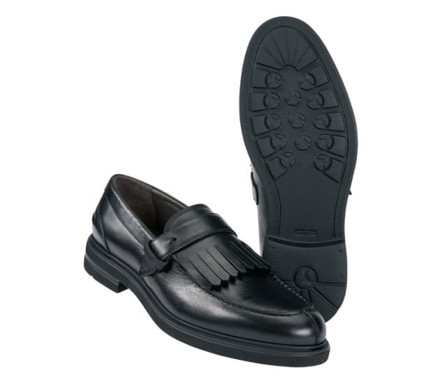 Ein Paar schwarze Leder‑Slipper mit Fransenverzierung und profilierter Laufsohle.