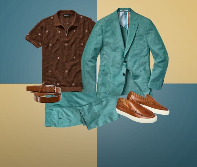 Zu sehen ist ein zusammengestelltes Outfit aus einem türkisfarbenen Anzug, einem braunen Strick‑Poloshirt, einem braunen Ledergürtel und braunen Loafern mit weißer Sohle.