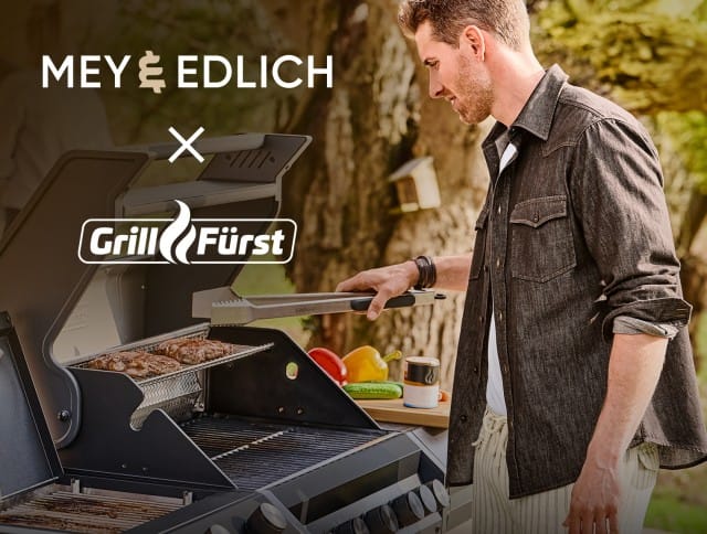 Ein Mann steht im Outdoorbereich vor einem Grill.