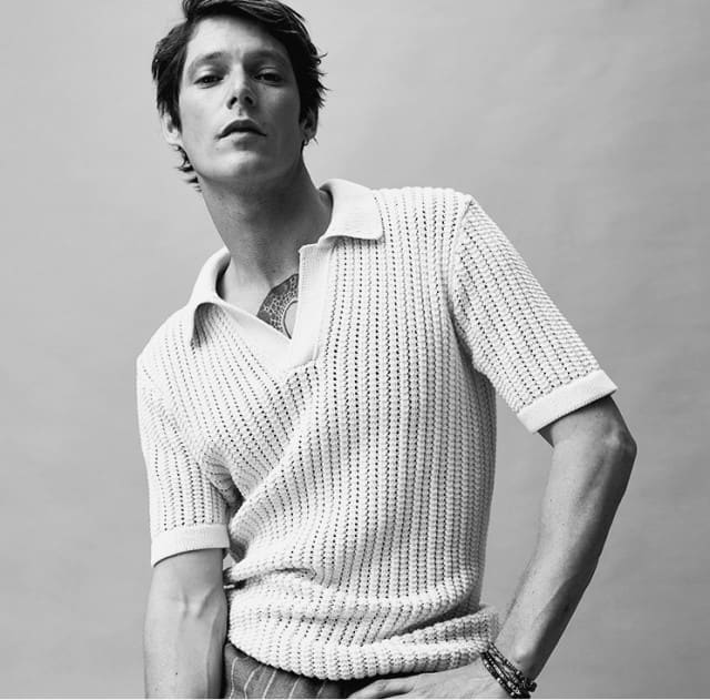 Strukturierter, hell gestricktes Shirt mit Polokragen, kombiniert mit einer lässigen Hose. Moderner, minimalistischer Stil.