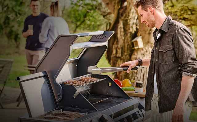 Mann steht am Grill im Freizeitlook