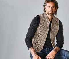 Mann in brauner Weste und schwarzem Sweatshirt