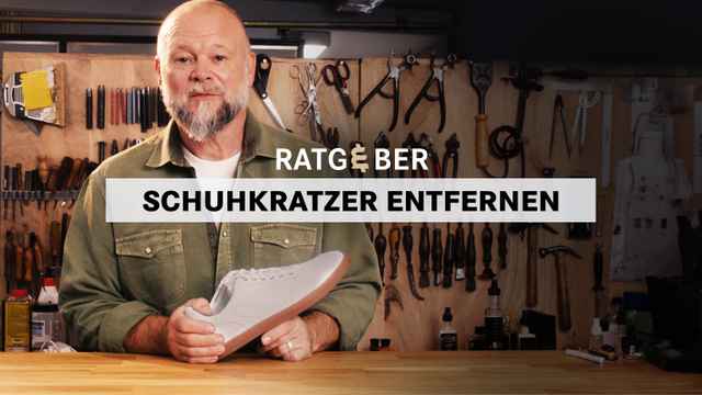 Ein Mann in einer Werkstatt hält ein Paar Turnschuhe; Text: "Ratgeber Schuhkratzer entfernen".