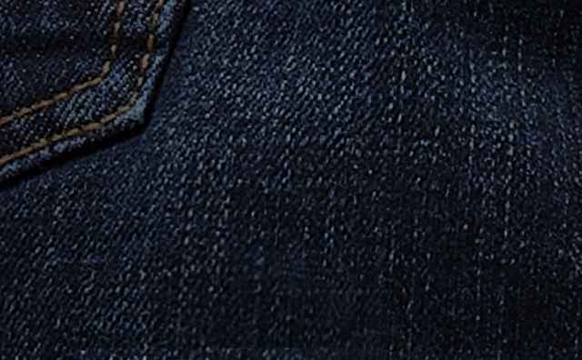 Nahaufnahme eines dunkelblauen Jeansstoffs mit einer Taschennaht.